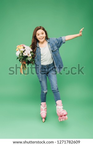 excited child in rollerblades with flower bouquet on green background