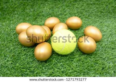 Tennis Easter Holiday with tennis ball and golf\den egg on green grass 