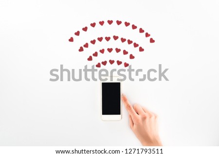 cropped image of woman using smartphone with blank screen under red heart symbols isolated on white, st valentine day concept