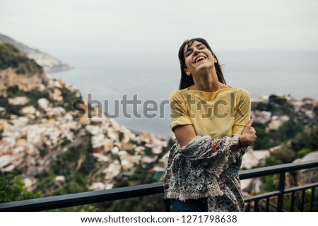 Smiling young woman enoying seaview in Positano,Italy. Vacation on Amalfi coast.Happy tourist in Europe.Italian coast beauty, woman enjoying scenic panorama.Experiencing italian lifestyle
