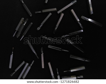 Many silver part of screwdriver in full picture with black background