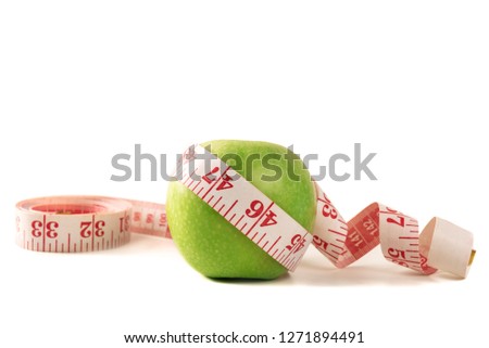 Green apple with measuring tape on white background.