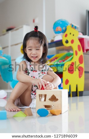 Happy Asian child girl playing with wooden blocks and having fun