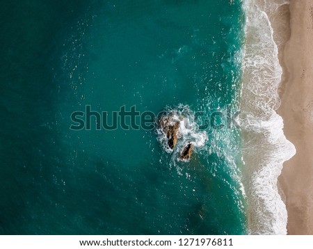 Aerial view of the ocean waves washing on the coast