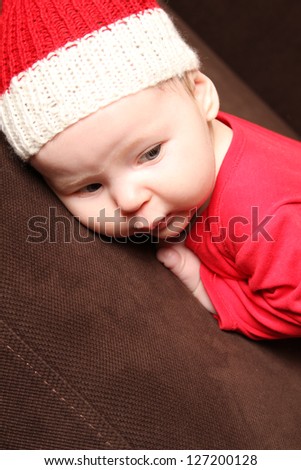 Close-up of a small child in a red knitted cap