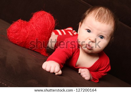Close-up of a small child in a red knitted cap