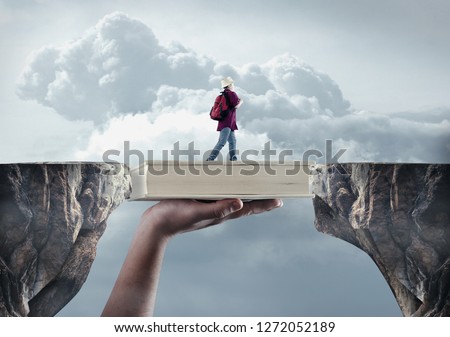 Young man passes from a peak to another on a book. The concept of scholarship. Royalty-Free Stock Photo #1272052189
