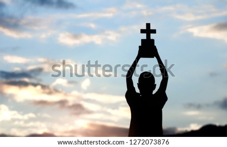 children holding christian cross and bible with sky background,christian concept.