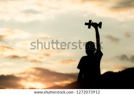 children holding christian cross with light sunset background,christian concept.