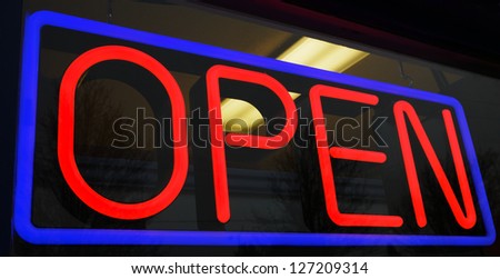 Red and blue neon open sign at store with background interior lights