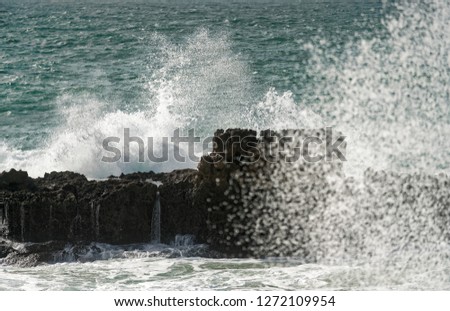 splits waves against rocks in the ocean