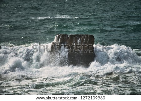 splits waves against rocks in the ocean