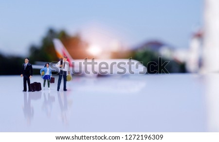 Travel concept.Traveler miniature peoples figure with bag walking on airport with airplane model.