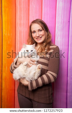 beautiful caucasian girl posing in a brown sweater with a cat in her arms