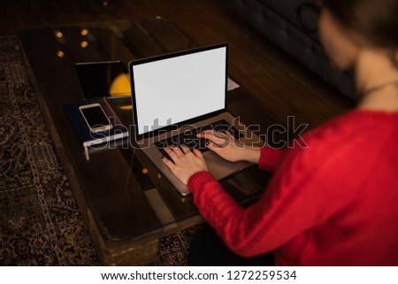 Hipster girl professional content writer keyboarding on laptop computer with white empty mock up copy space on the screen background for promotional text message while sitting at the table in home