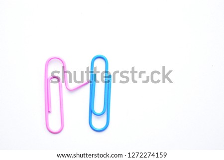 Two paperclips lie on a white surface - one of the paperclips puts its arm on the other's shoulder to symbolize that it is there for the other - concept as a symbol of connectedness and help