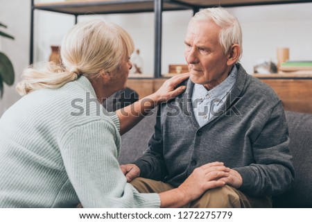 retired couple holding hands and looking at each other at home  Royalty-Free Stock Photo #1272275779