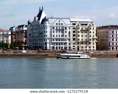 

Residential mid-rise condominium & apartment buildings along the Danube in Budapest in the summer with small tour boat on the blue river. Budapest is a popular travel destination with many landmarks