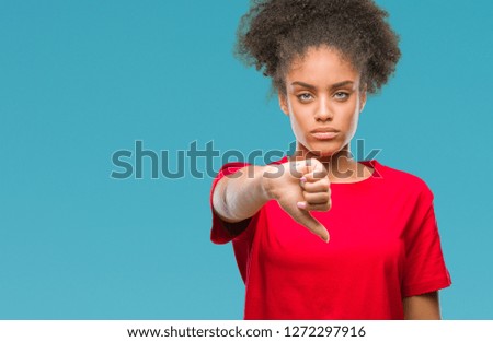 Young afro american woman over isolated background looking unhappy and angry showing rejection and negative with thumbs down gesture. Bad expression.