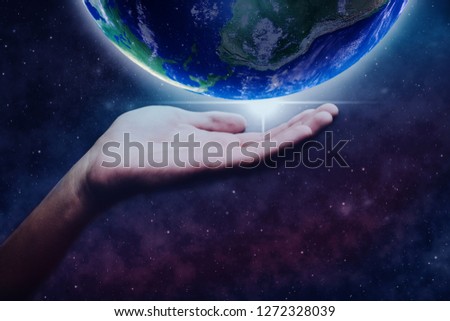 Protect our world in human hands and nebula dust. Mixed media .Elements of this image furnished by NASA.