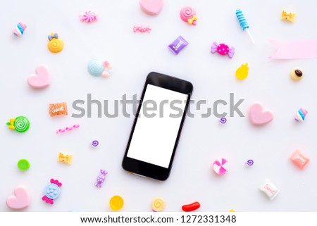  blank screen on smartphone cell phone, tablet with sweet candy on white background, valentines day background.