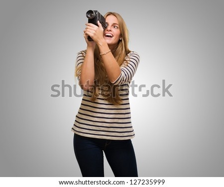 Woman Looking Through A Camera against a grey background