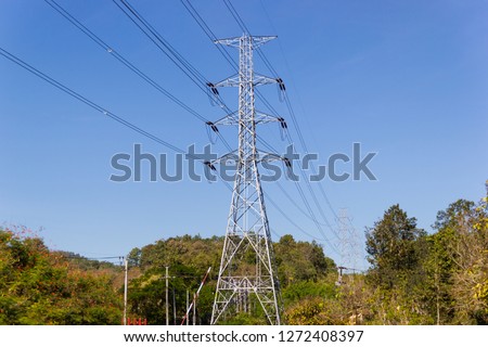 High voltage transmission towers with mountain Background and blue sky