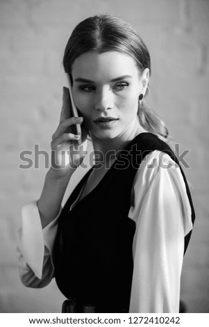 black and white photo of woman in formal wear talking on smartphone