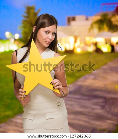 Portrait Of Young Woman Holding Yellow Star, outdoor