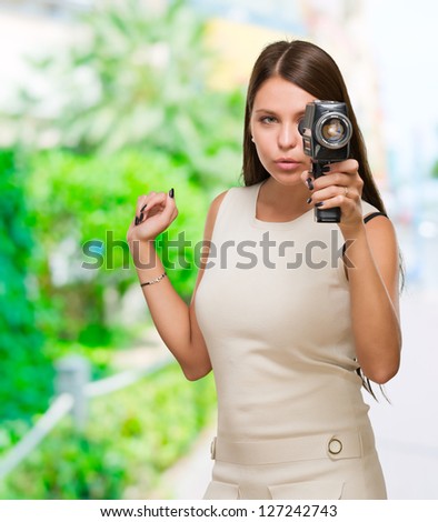 Young Woman Holding Camera against a nature background