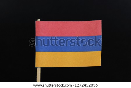 A unique and simple flag of Armenia on toothpick on black background. A horizontal tricolour of red, blue, and orange.