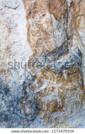 Baikal Lake. Rock paintings of ancient deers and the warrior on horse on the famous rock of Sagan-Zaba. Tourist landmark