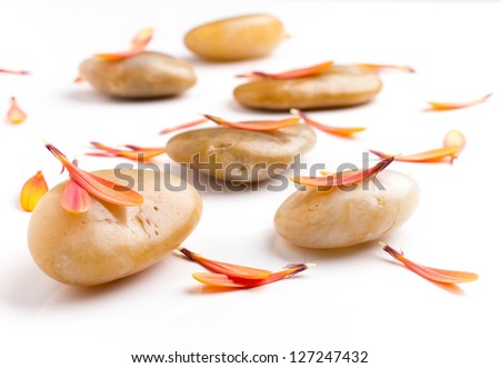 Spa stones and orange leaf, isolated on white background.