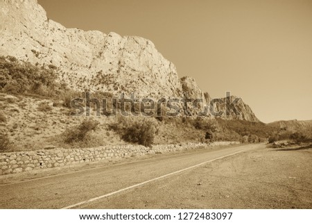 Crimean peninsula. In the frame of the mountain and the highway without cars, there are no people. Picture taken in Ukraine. Horizontal frame. Black and white image. Sepia