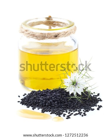 Black cumin oil and seeds on white background