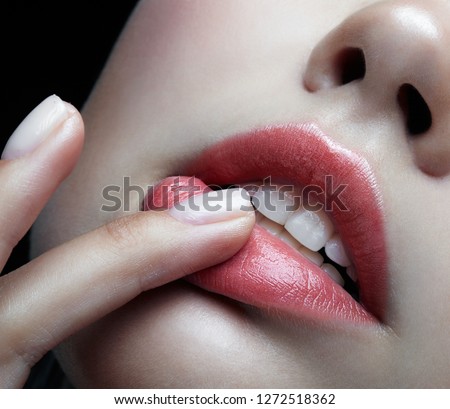 Closeup macro portrait of female part of face. Human woman lips with day beauty makeup. Girl with perfect plump  lips shape an finger on lips. Royalty-Free Stock Photo #1272518362