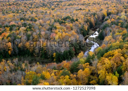 A High Angle Shot on the Carp River Cutting Through Dramatic Autumn Colors in the Landscape of the Porcupine Mountains in Michigan