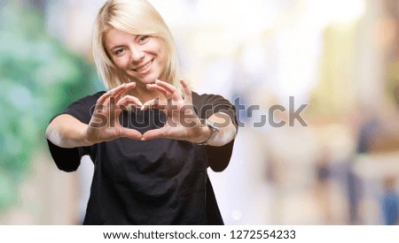 Young beautiful blonde woman over isolated background smiling in love showing heart symbol and shape with hands. Romantic concept.