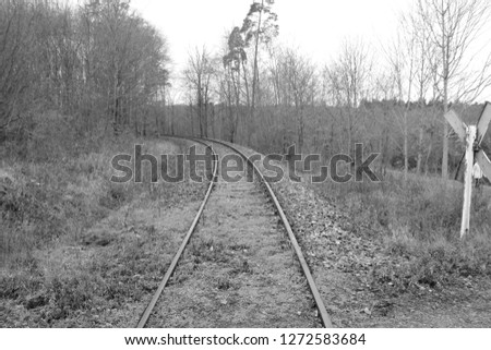 Railway tracks run away from the viewer in a curve. The picture was developed in black and white.