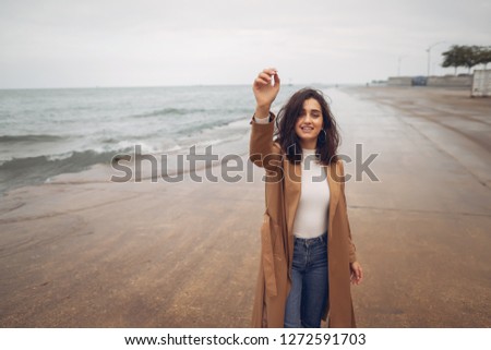 young girl walking on the beach during autumn