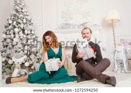 Happy Family Couple Exchange Presents on white background with fireplace and christmas tree