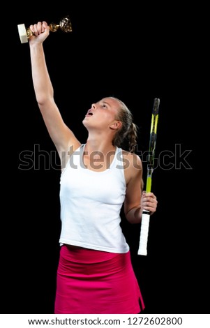 Beautiful girl tennis player with a racket on dark background wiht lights celebrating flawless victory