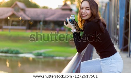 Close up image of young woman holding dslr camara.