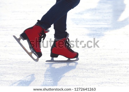Female legs in skates on an ice rink
