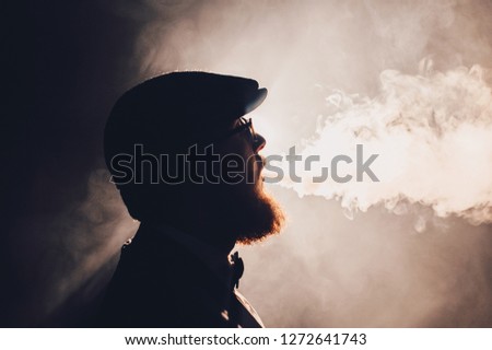 Retro portrait of a young man smoking hookah in the cafe or bar close up. Concept of having a good time in retro style. silhouette close up view