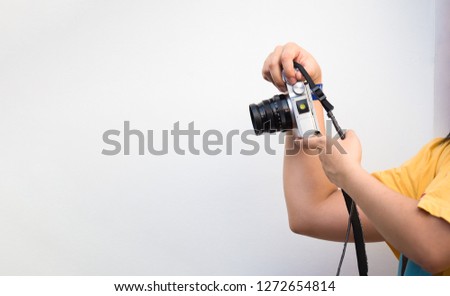 young girl hands holding a camera to take photo of something, hobby lifestyle in city