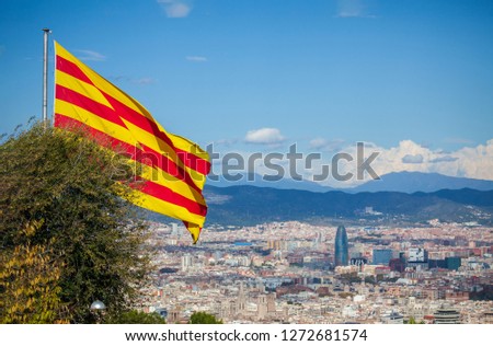 Catalonian flag waving on the mount Montjuic over the cityscape of Barcelona, Spain