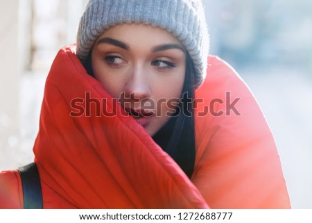 Close up portrait of pretty fashion woman in red coat and grey hat. Beauty fashion style. Christmas, new year and winter holiday concept