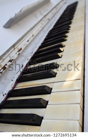 Close look on the old white colored piano keyboard