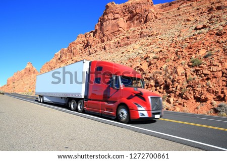 Red semi truck driving through Southwest, Arizona-USA Royalty-Free Stock Photo #1272700861